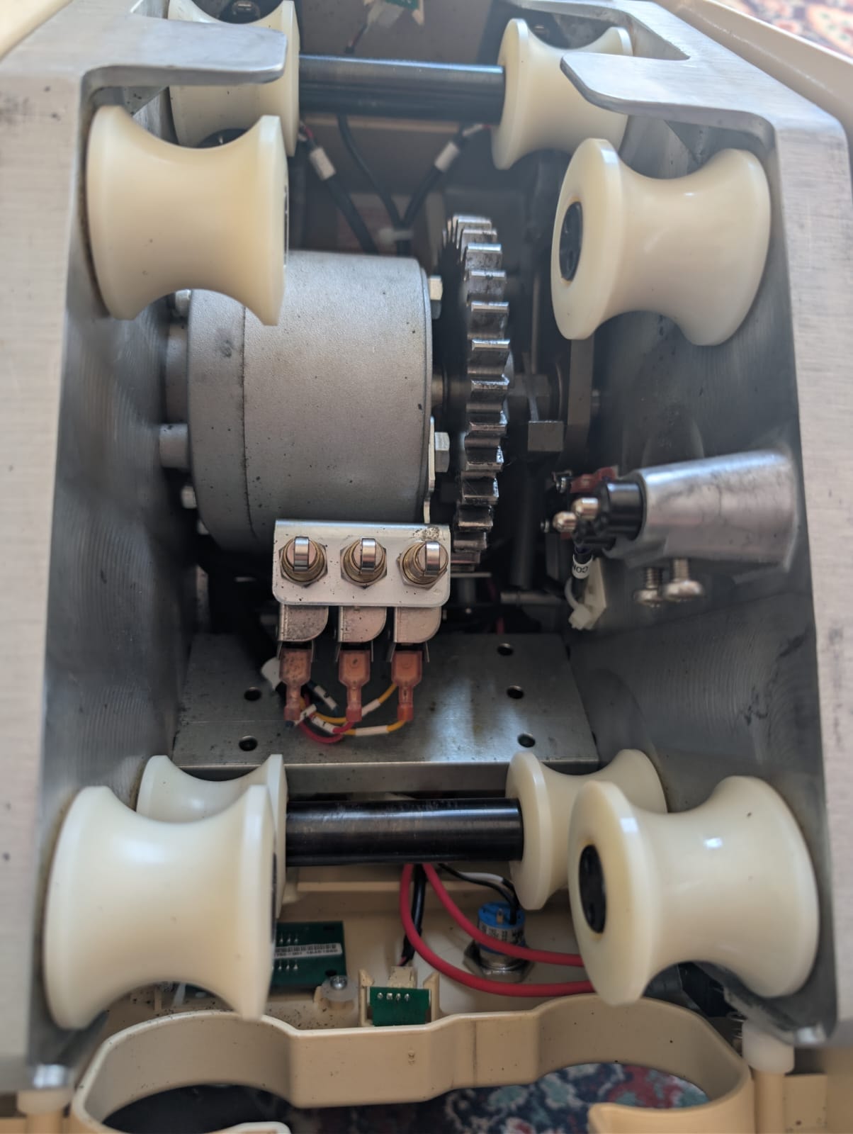 Internal components of stairlift carriage showing rollers, pinion wheel, OSG and wiring
