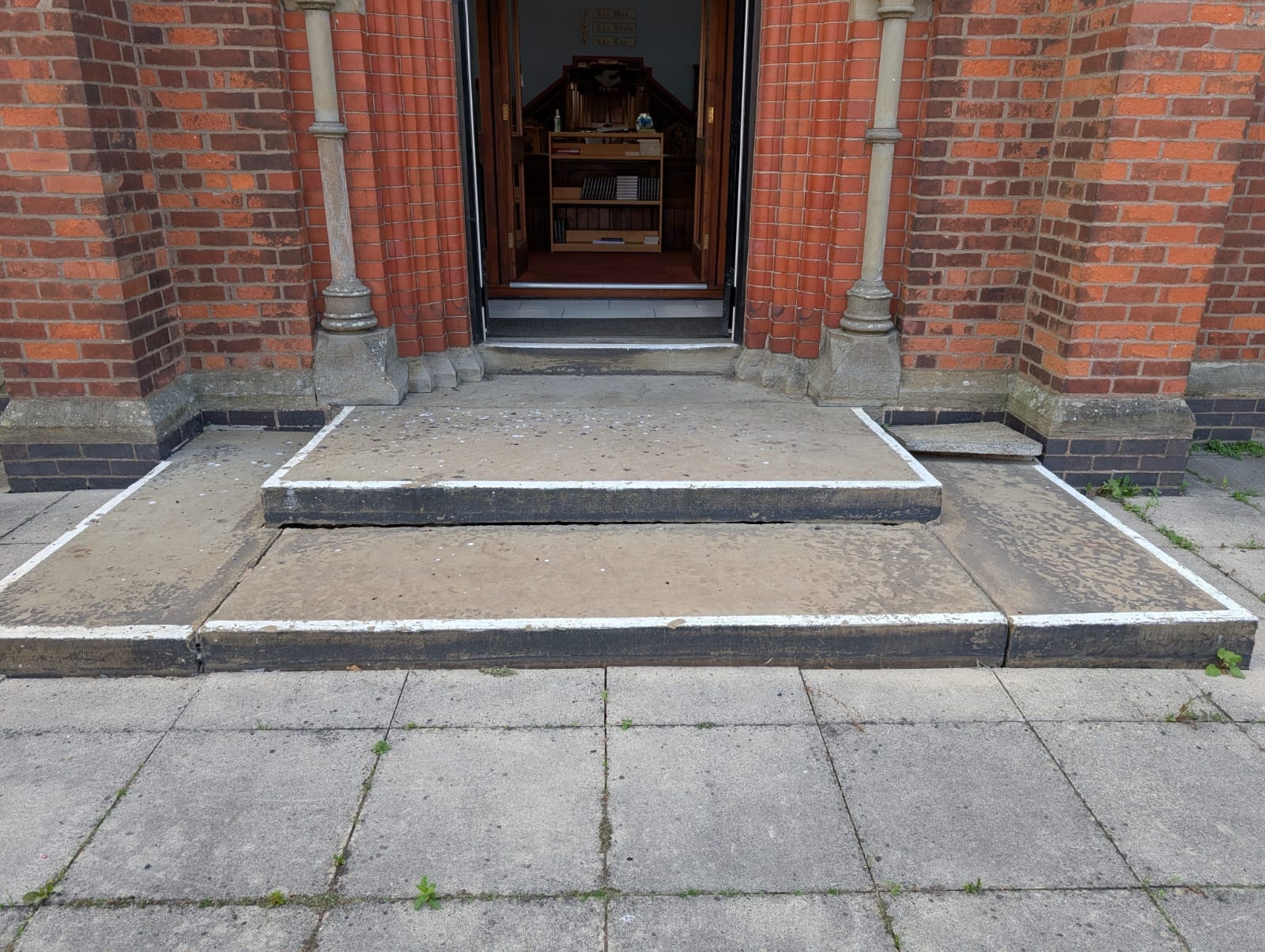 Church entrance before installation — two raised steps with no wheelchair access